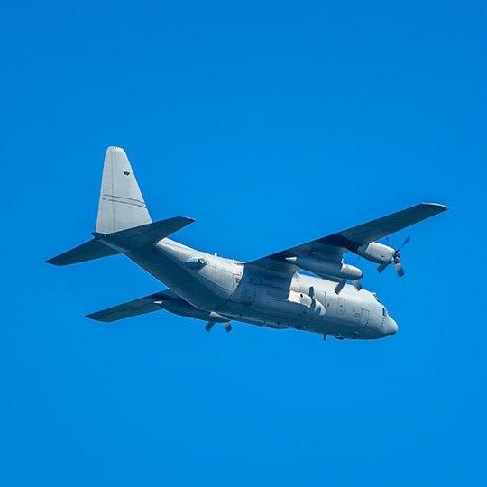 Mulitary aircraft flying against a bright blue sky
